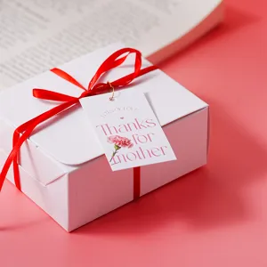 Mother's Day gift box packaging tag detail view, decorative floral bouquet cake label with red ribbon.