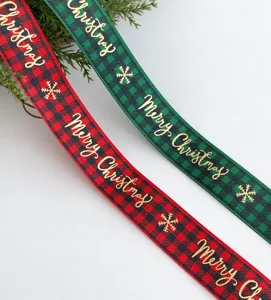 Close-up detail view of red and green plaid Christmas ribbon featuring gold lettering.