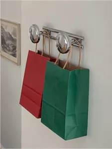 Dettaglio sacchetti regalo di carta natalizi rossi e verdi che mostrano borsa festiva.