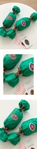 Detailed view of Christmas pom-pom decorative ribbon string and festive gift wrapping accessories.