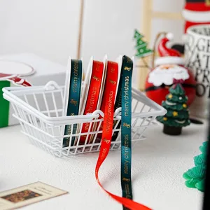 Close-up detail of Christmas ribbon with merry christmas text and gold foil bell motifs.