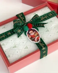 Red green plaid Christmas ribbon gift box wrapping decorative bow with Santa tag.