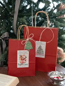 Sacchetti regalo di carta rossa di Natale con manici, dettaglio confezione festa rustica.