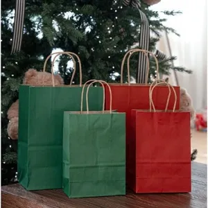 Sacchetti regalo di carta kraft rossa e verde di Natale con manici per le feste.