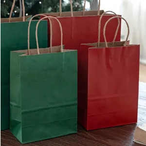 Sacchetti regalo di carta kraft natalizi rossi e verdi con manici per feste ed eventi.