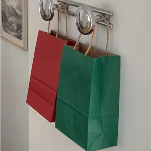 Sacchetti regalo di carta rossi e verdi di natale con manici per confezioni festa.