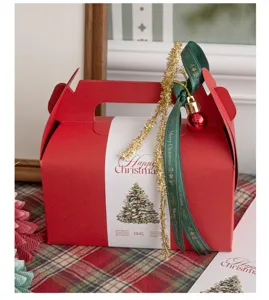 Set de caja de regalo de Navidad con caja roja, cinta verde festiva y oropel dorado.