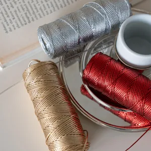 Detailed close-up of shiny metallic craft cord, gold silver red wrapping string.