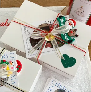 Boîtes cadeaux décoratives de Noël avec cloches et rubans pour bricolage DIY et déco de fête.