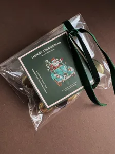 Set confezione regalo di Natale con campanelle dorate, nastro di velluto e biglietto.