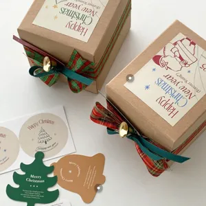 Ensemble de boîtes cadeaux décoratives de Noël avec rubans à carreaux et cloches dorées.