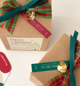Ensemble d'accessoires d'emballage cadeau de Noël avec rubans écossais et cloches dorées.
