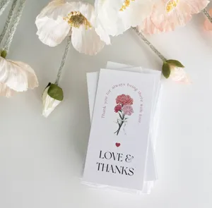 Primer plano detallado de tarjetas de felicitación blancas con diseño floral y mensajes.