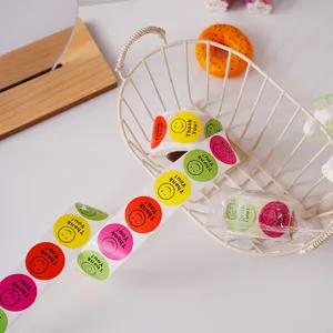 Vue détaillée du rouleau d'autocollants smiley colorés avec texte de remerciement sur fond blanc.