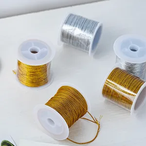 Vue en gros plan de fils artisanaux dorés et argentés métalliques sur bobines transparentes