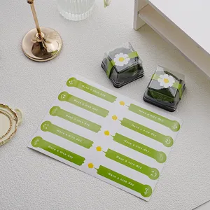 Vue détaillée d'autocollants de scellage verts avec design de fleurs pour emballage cadeau.
