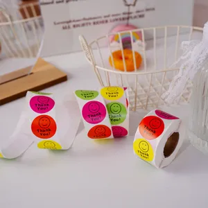 Gros plan détaillé de rouleaux d'autocollants colorés ronds smiley de récompense avec texte.