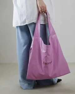 Purple soft leather tote bag detail view, casual large capacity shoulder bag lifestyle shot.