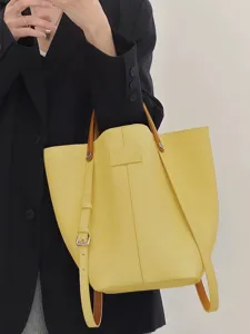 Yellow leather bucket bag for women, stylish tote shoulder bag with top handle and strap.