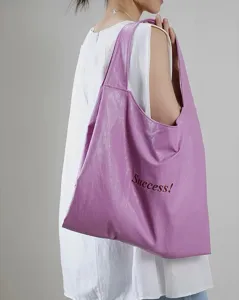 Purple soft leather shoulder tote bag detail shot, stylish everyday casual accessory.