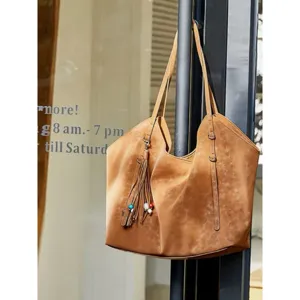 Detail sac cabas en suede vintage avec pompon, grand sac epaule de travail decontracte et chic.
