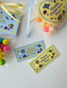 Cute cartoon rectangular gift tags and transparent candy bags set for student party favors.
