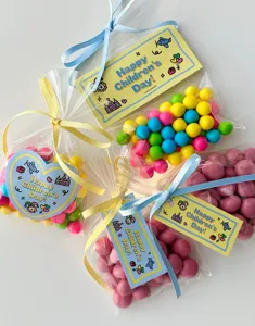 Cute children's day candy gift bags with colorful ribbons and cartoon decorative tags.