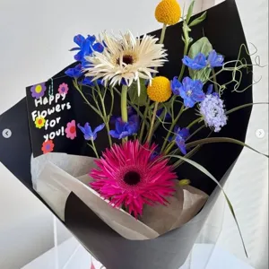 Ramo de flores estilo ins con papel de regalo negro y tarjeta de felicitación para cumpleaños.