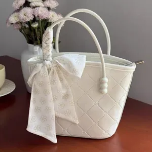 White quilted handbag for women, sweet tote bag with elegant ribbon bow and pearl details.
