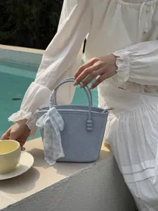 Light blue quilted bucket bag with floral scarf accessory, stylish resort handbag for women
