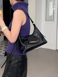 Detailweergave van minimalistische zwarte lakleren schoudertas, stijlvol hobo-ontwerp.