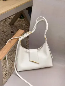 Minimalistische witte schoudertas detail met fijn leer en elegante gouden hardware accessoires.