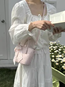 Pink quilted bucket bag with sweet ribbon scarf, chic women handbag for spring resort style.