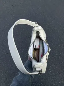 Nahaufnahme der Details des weißen Y2K Leder Hobo Schultertasche Innenraums und Textur.