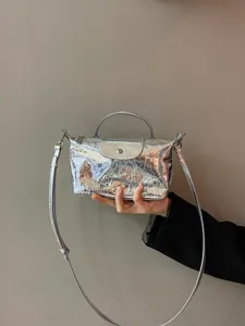 Metallic silver crinkled leather crossbody dumpling bag with top handle and flap closure.