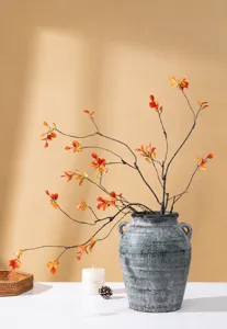 Artificial red maple branches in retro vase, perfect for cozy living room home autumn decor.