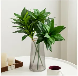 Artificial lily bamboo plant in glass vase, elegant green foliage for indoor home decor.