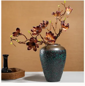 Künstliche Magnolienzweige mit strukturierter Keramikvase für elegante Heimdekoration.