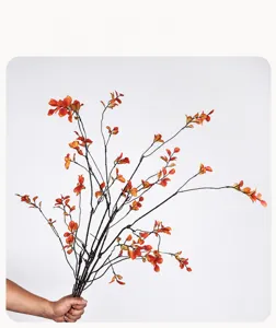Detailed shot of artificial autumn maple leaf branches, realistic red foliage for vase decor.