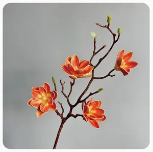 Nahaufnahme eines künstlichen Magnolienblütenzweigs, realistische orange Deko-Pflanze.