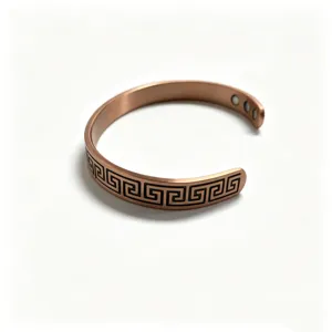 Close-up of open copper magnetic cuff bracelet with geometric key pattern and inside magnets.