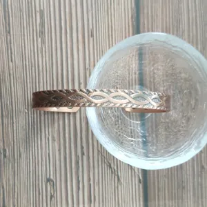 Bracciale rigido magnetico in rame retrò con motivo intrecciato infinito e magneti incorporati.