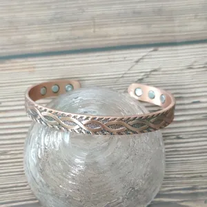 Vista dettagliata del bracciale magnetico in rame vintage con motivo intrecciato e magneti inclusi.