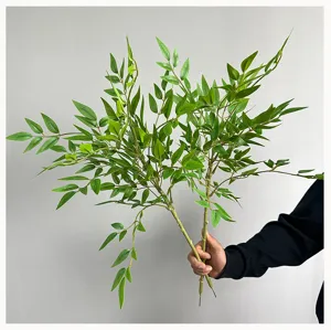 Détail de branche de bambou Nandina artificiel, feuilles vertes réalistes pour décoration d'intérieur.