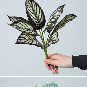 Detalle de hojas de plantas verdes artificiales, rama de hojas realistas para decoración del hogar.