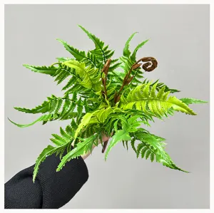 Artificial fern leaf detail shot, realistic green plant greenery foliage decor for interior display.