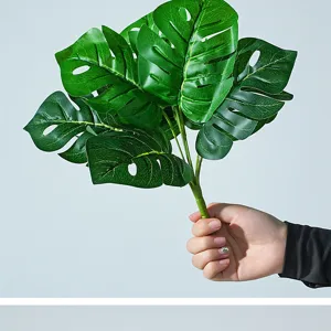 Detalle de hoja de monstera artificial, follaje de planta tropical verde para decoración del hogar.