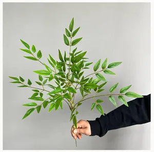 Feuilles de nandina artificielles branche de plante verte gros plan detail decoration