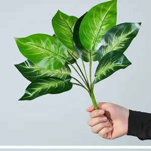 Vista detallada de hojas de plantas verdes artificiales, textura realista para hogar.