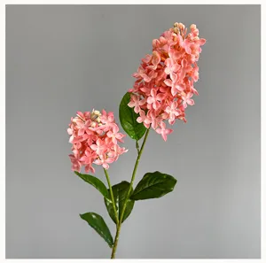 Detailopname van een kunstmatige roze syringa bloementak met groene bladeren voor decoratie.